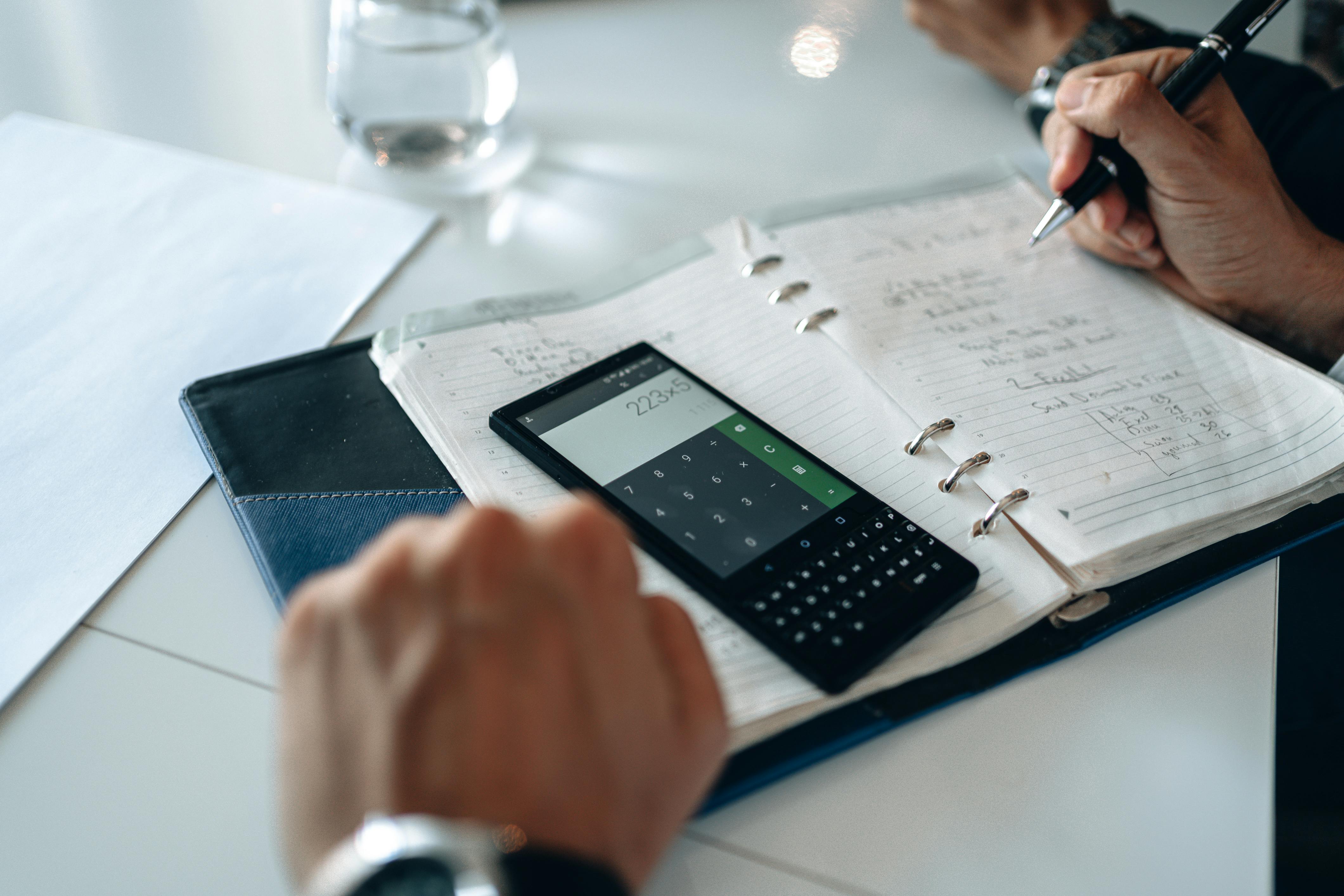 Calculator on a pad with man making notes