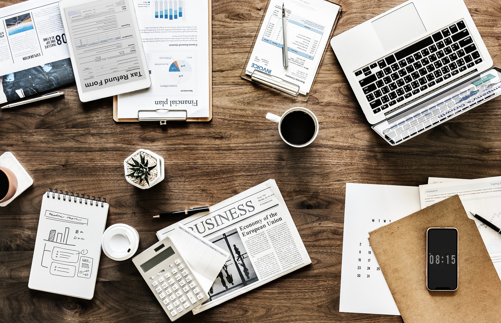 Desk With Business Papers, Calculator, Notepads and Laptop