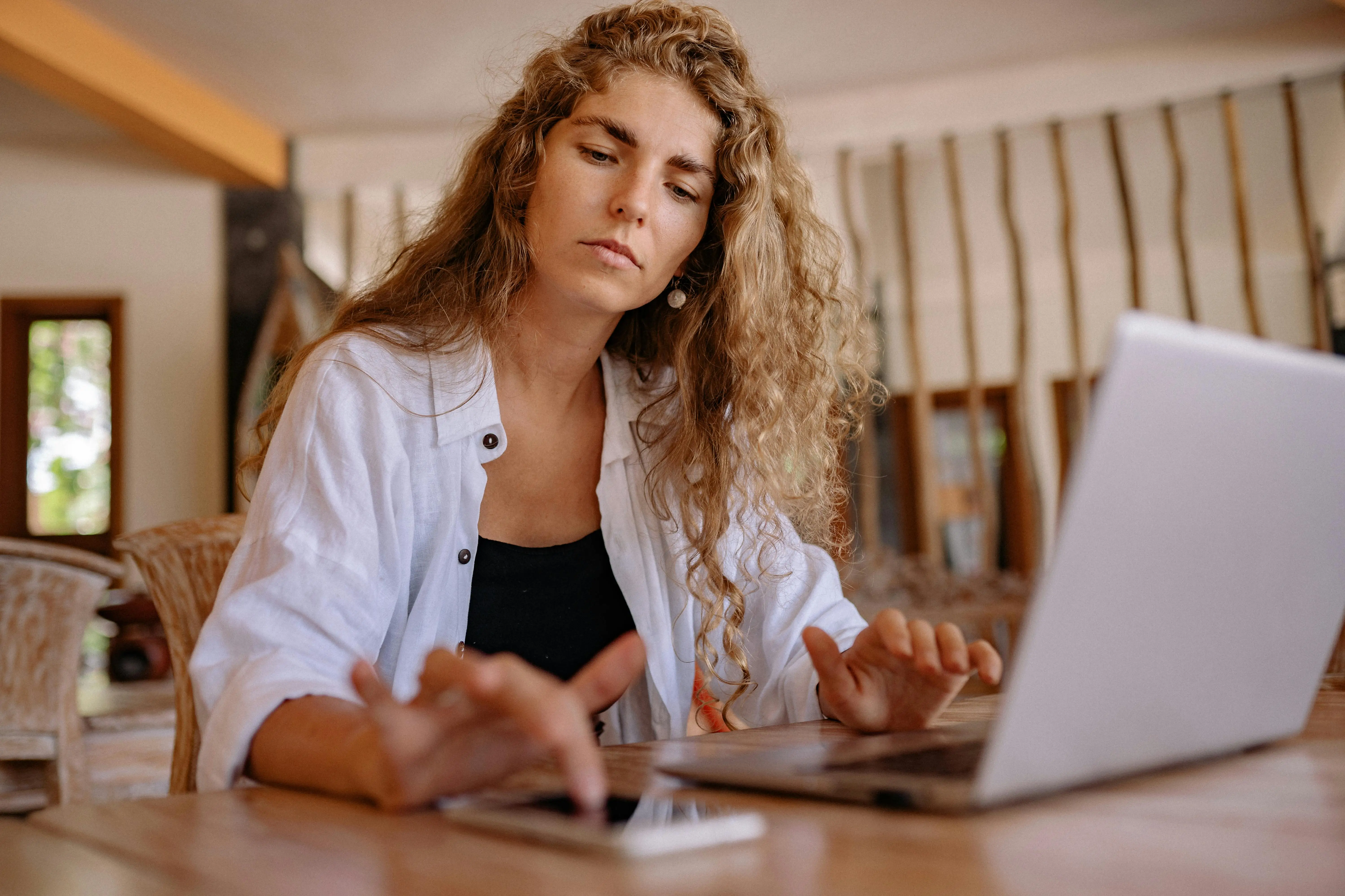 Woman on Laptop Using Phone