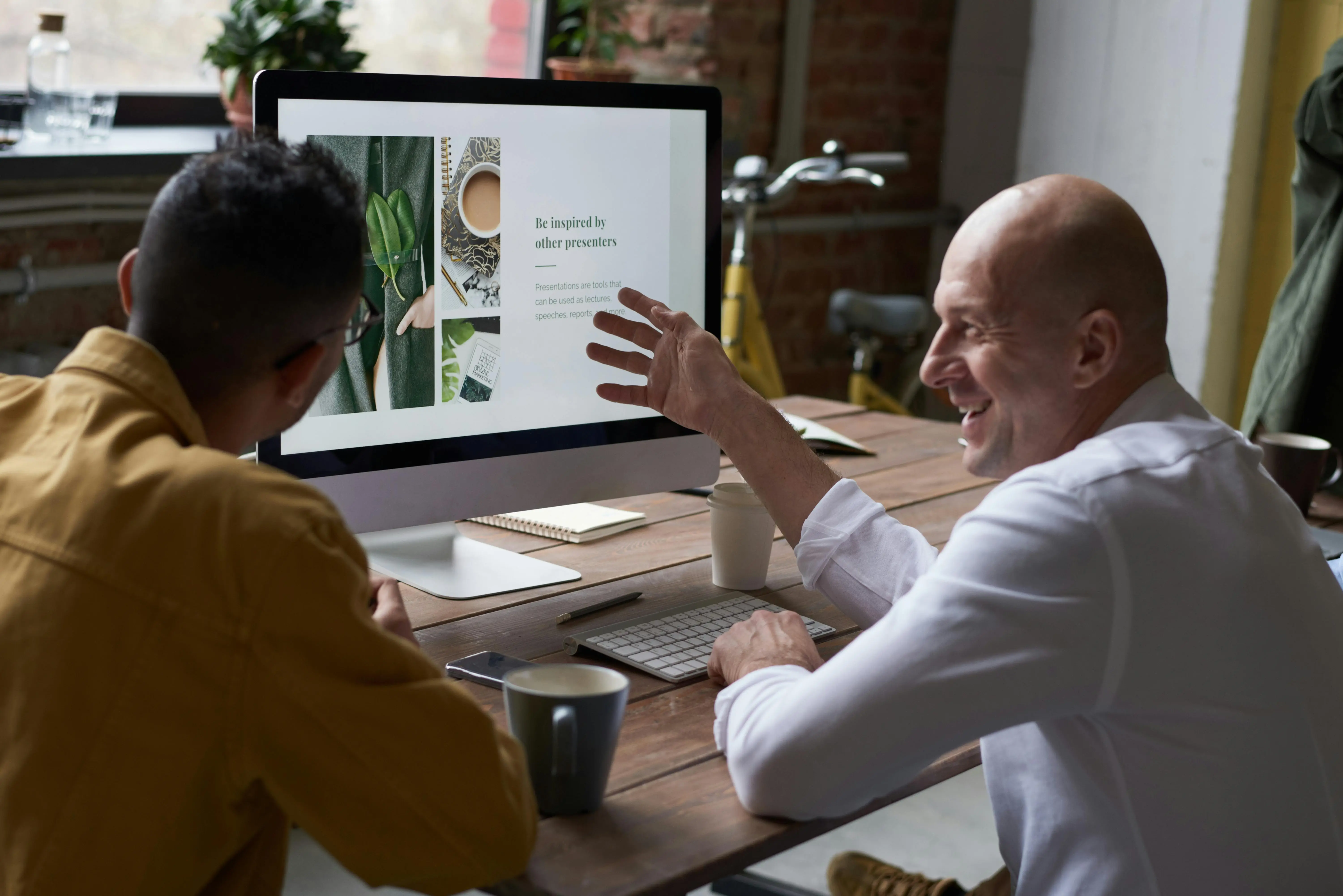 Two men in conversation looking at a computer screen