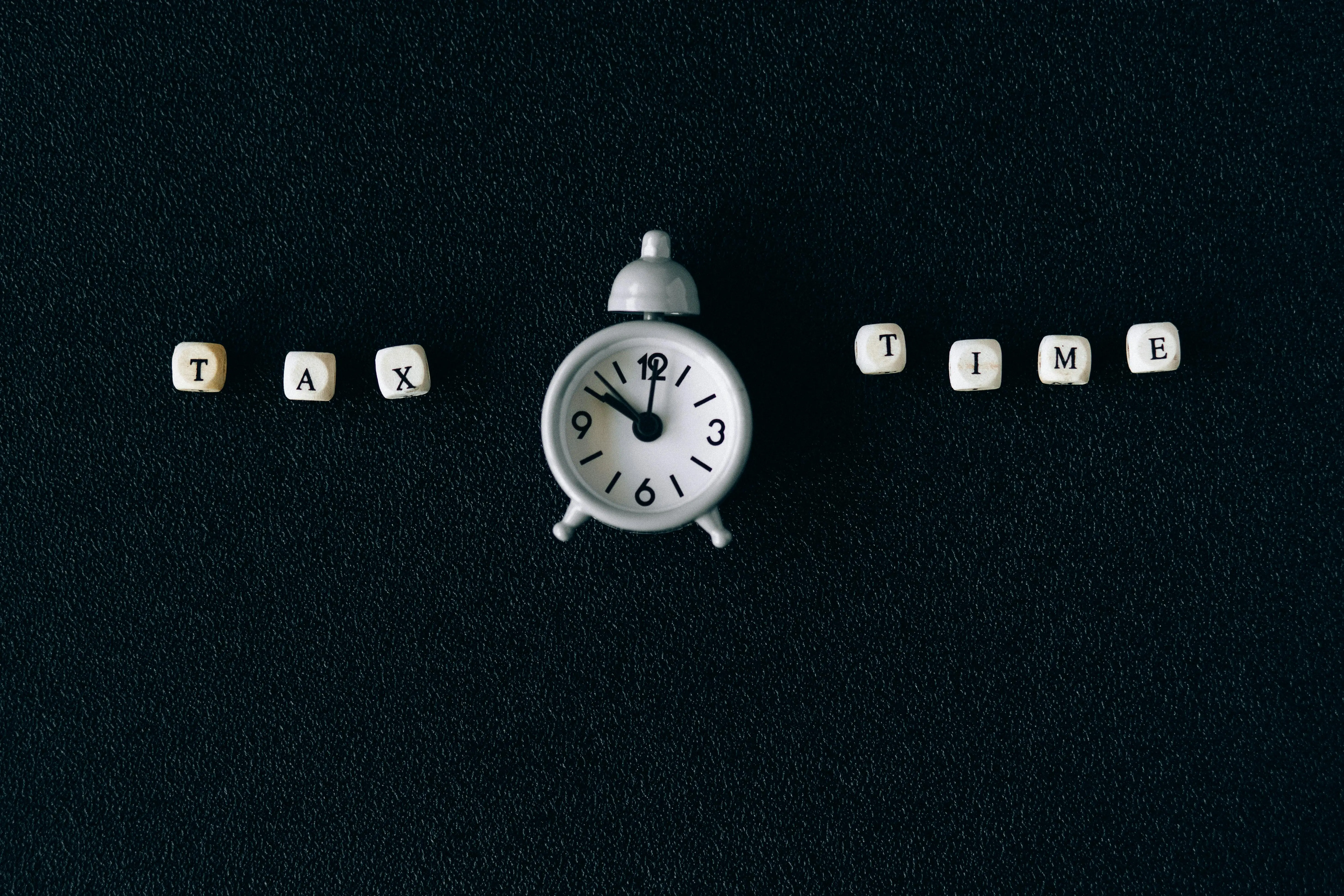 Tax Time Written on Dice Around an Alarm Clock